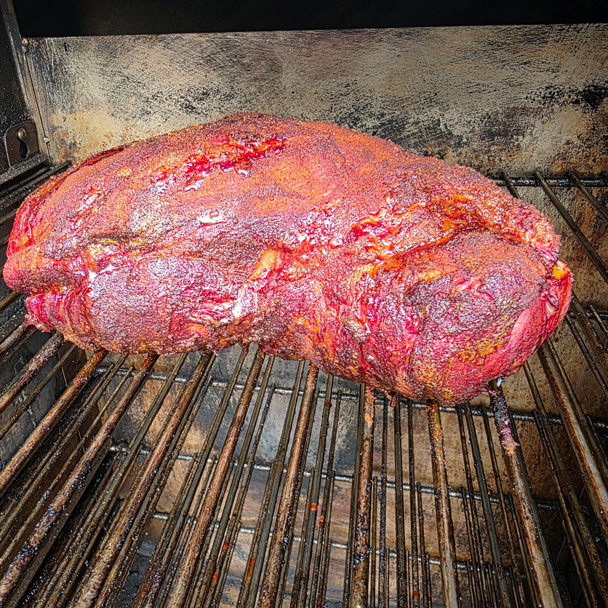 Smoked pork shoulder seasoned with Memphis Pig Rub BBQ spice, showcasing a flavorful crust from the sweet and savory rub.